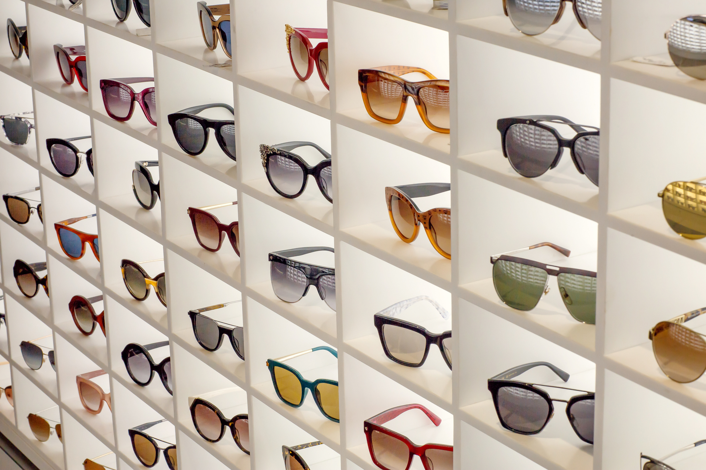 Various different sunglasses in the shop display shelves